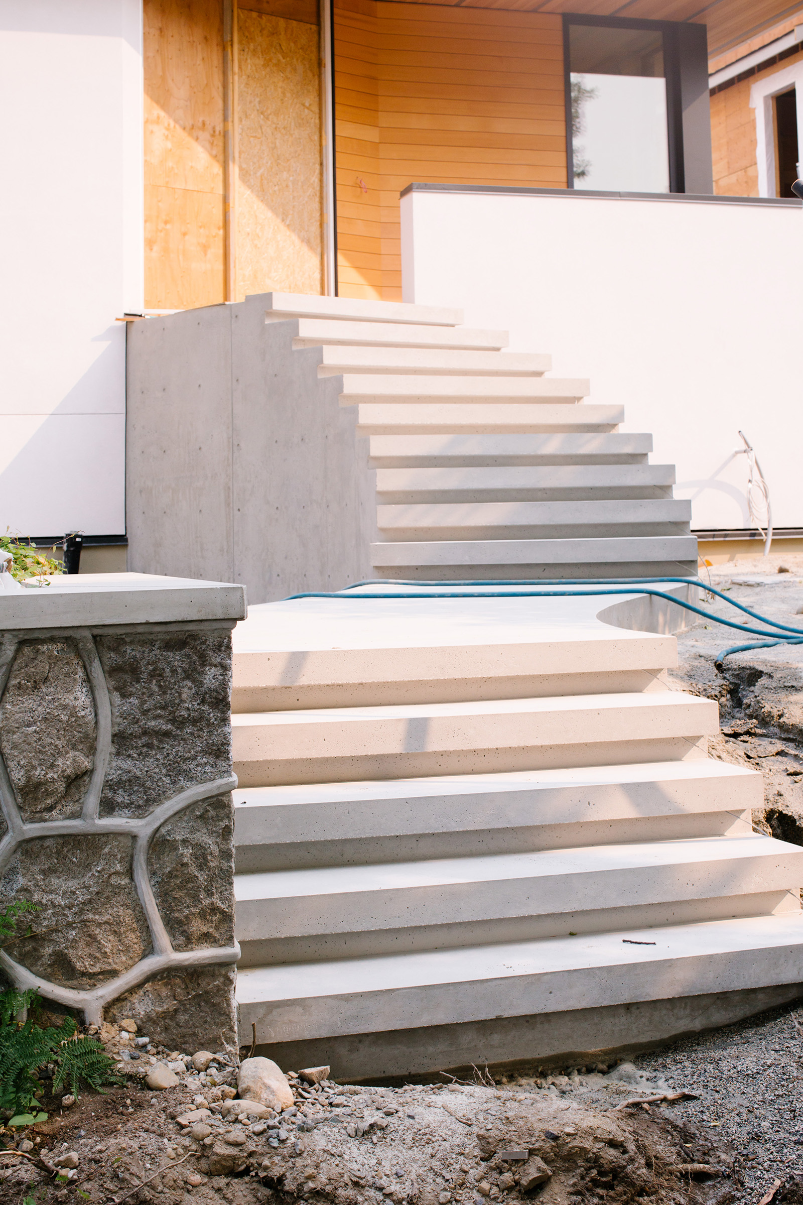 Curved concrete stairs lead to front entrance of a home