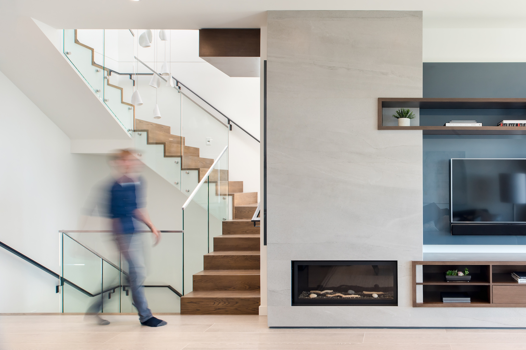 A blurred figure walks through a contemporary living room