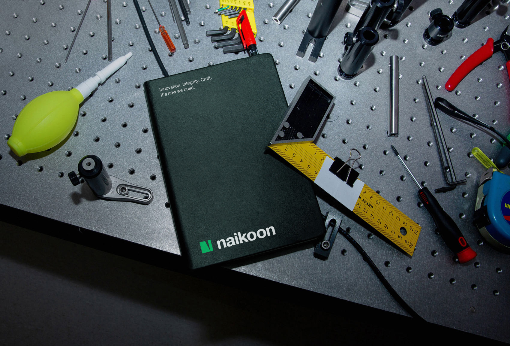 Cover of branded notebook on table scattered with tools