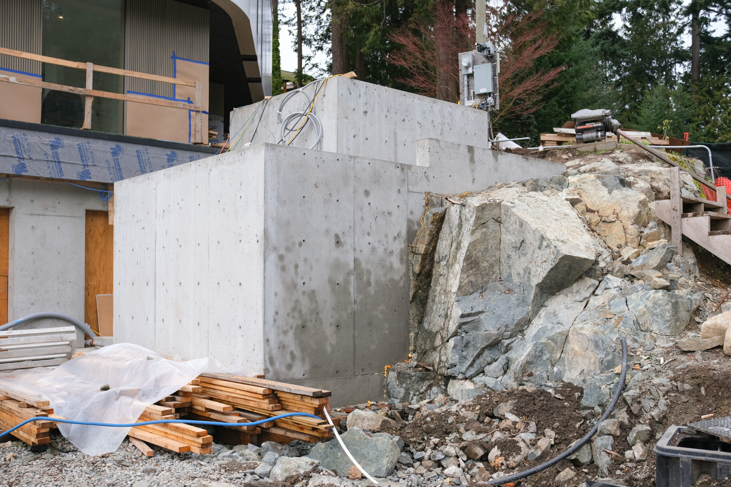 Concrete foundation walls anchored into exposed bedrock during hillside custom home construction