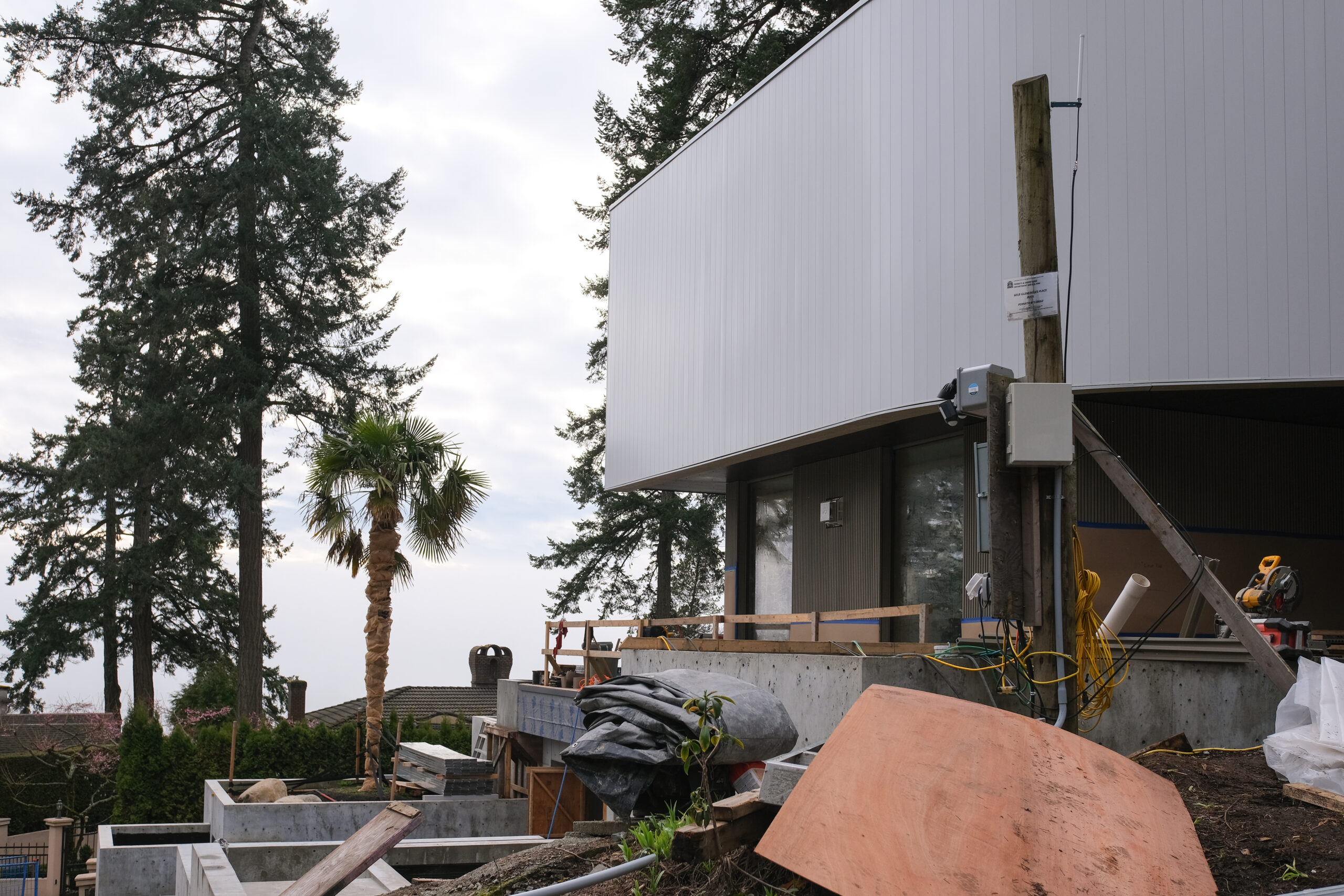 Contemporary custom home under construction with cantilevered upper floor and concrete base
